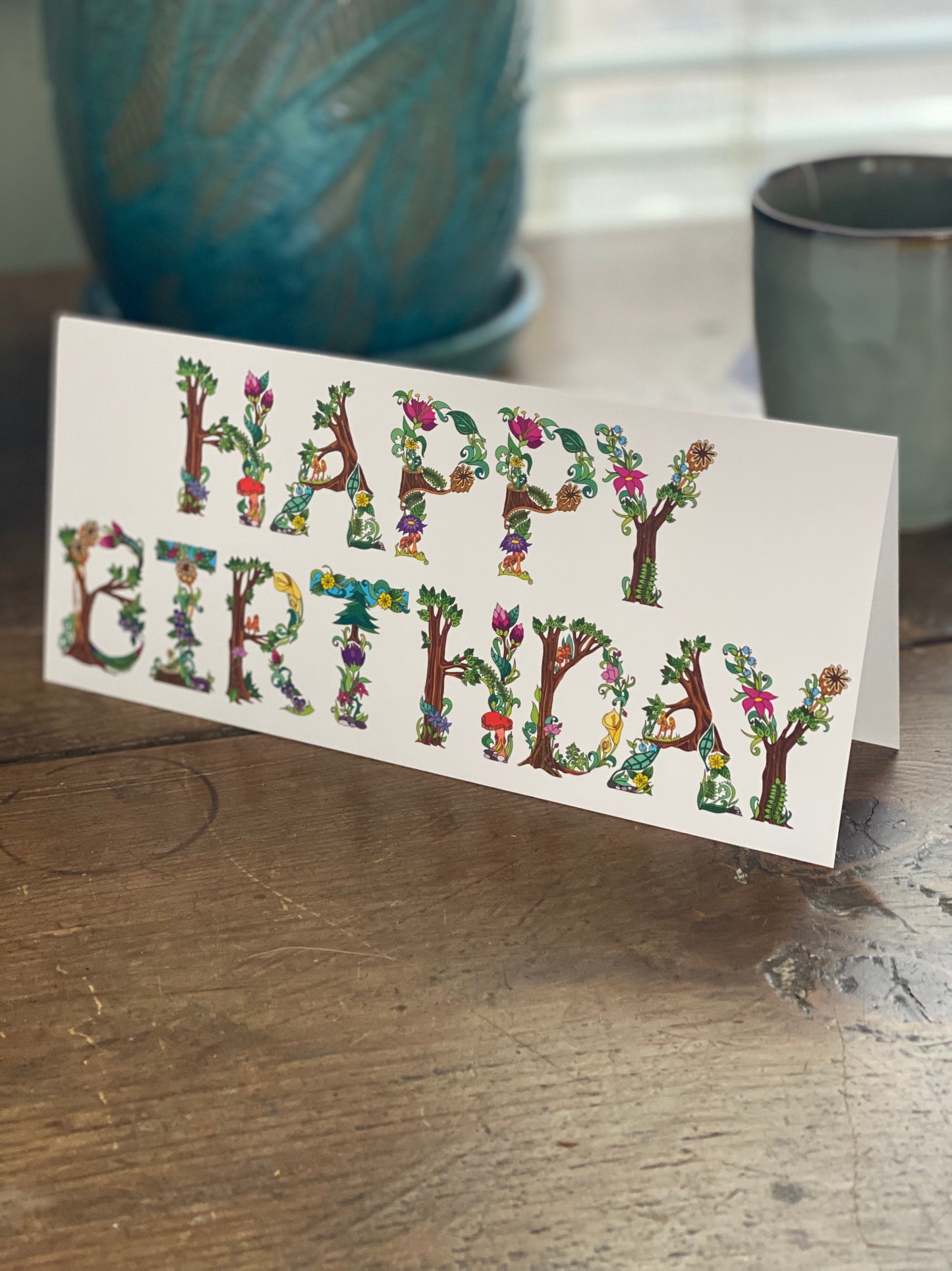 greeting card with botanical alphabet spelling the words happy birthday.
