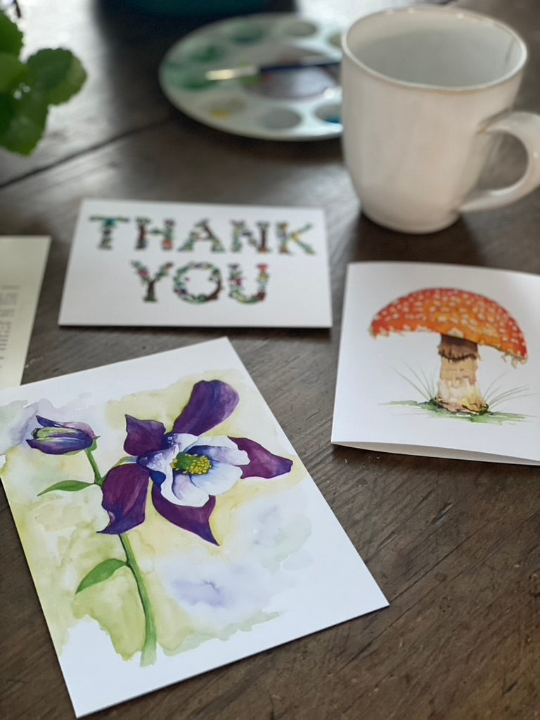 a collection of three greeting cards including one with a watercolor painting of a purple columbine flower.