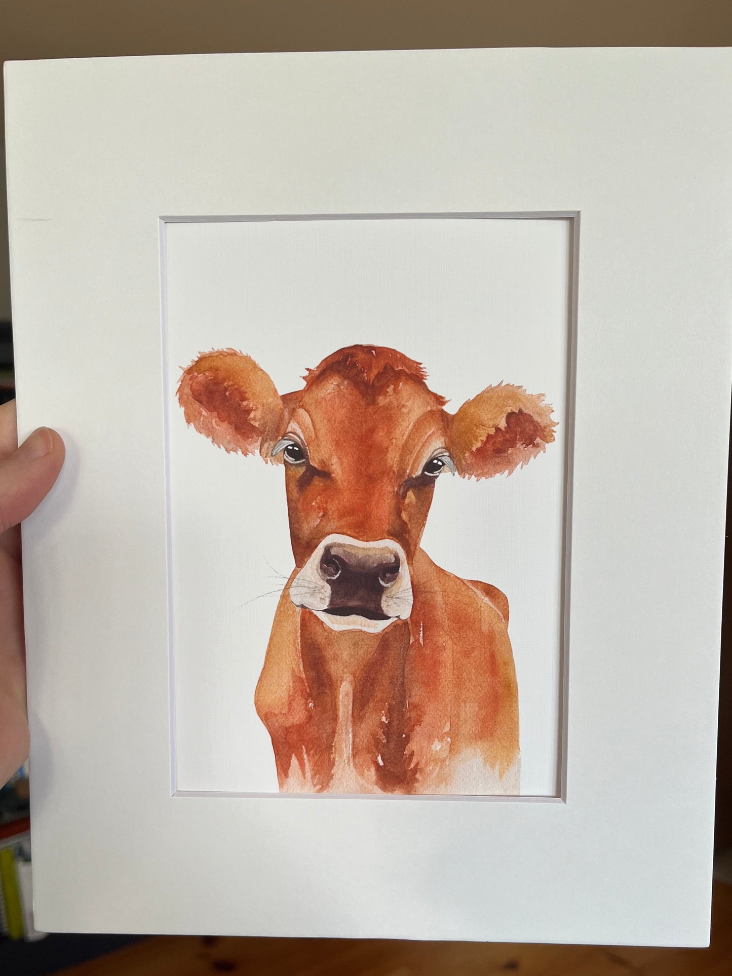Matted watercolor painting of a jersey cow.