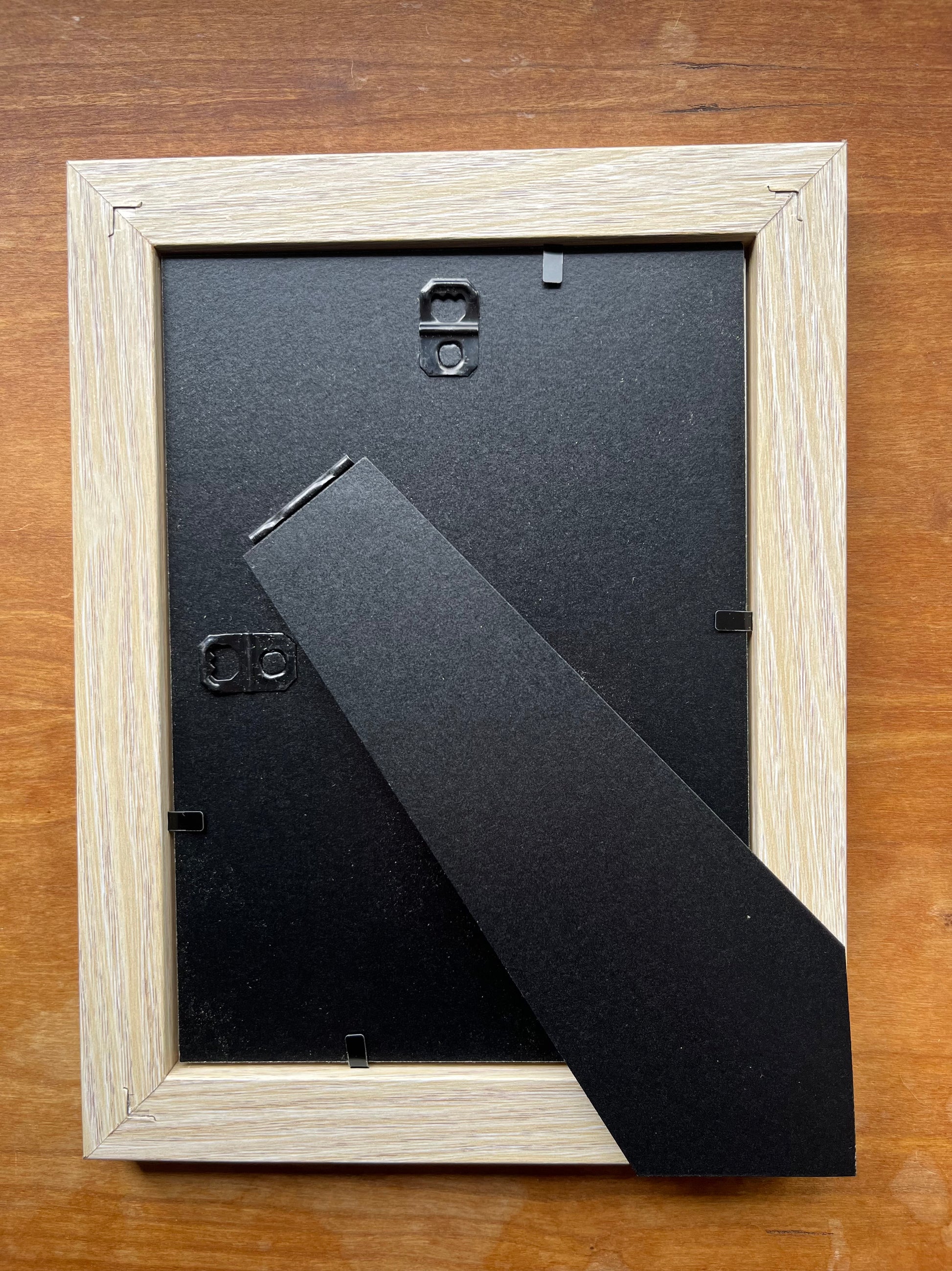 Back of blonde wood picture frame.