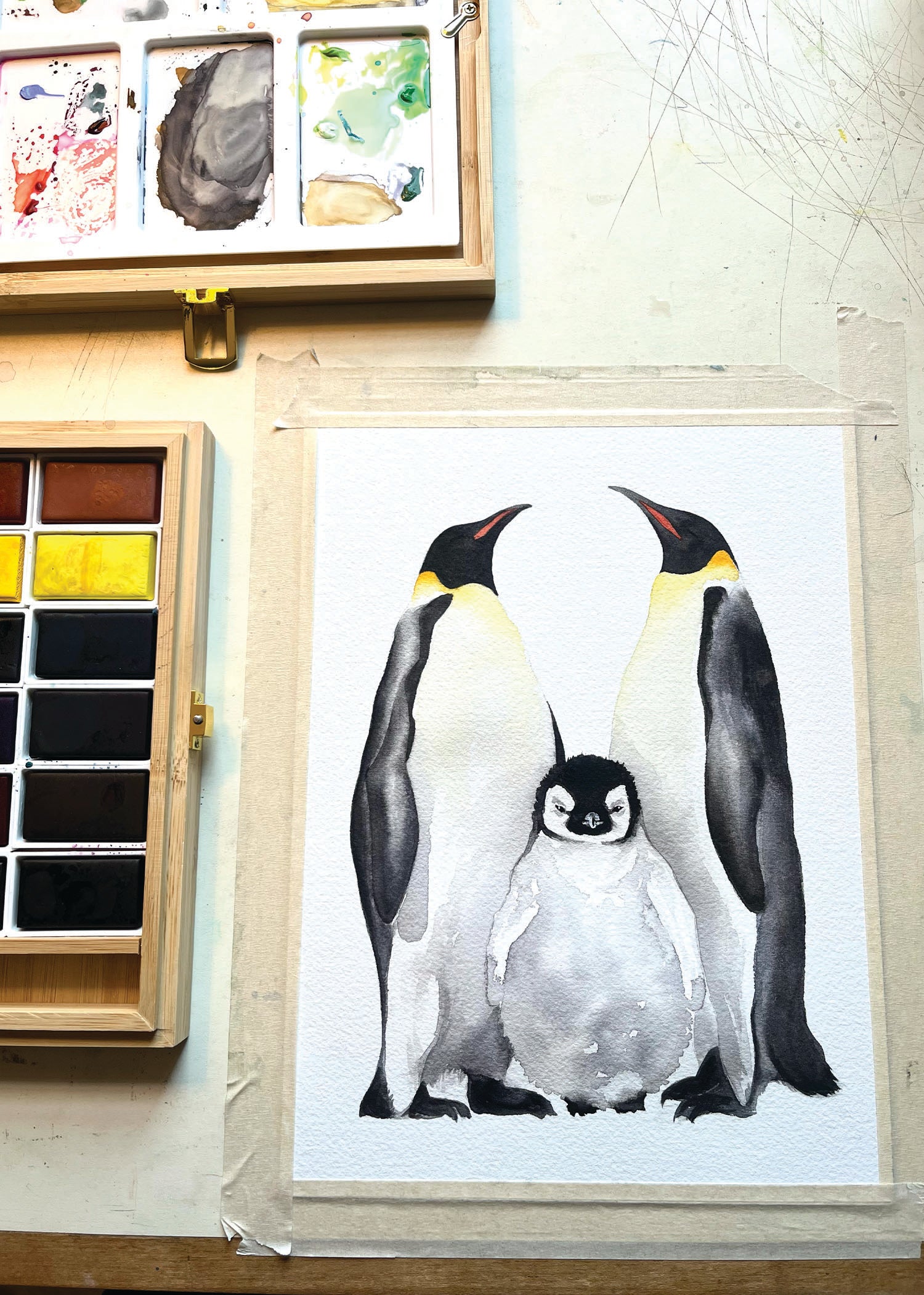 Watercolor painting of an emperor penguin family.
