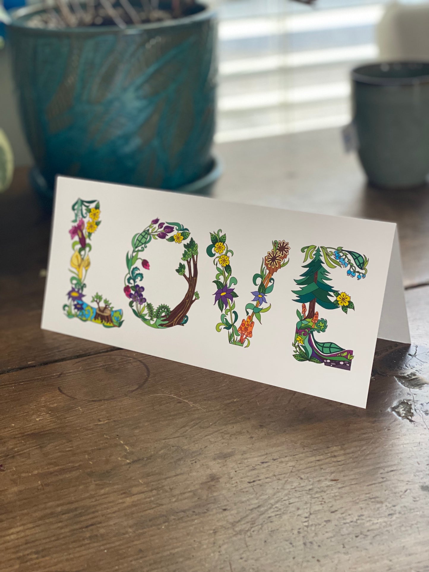 greeting card with botanical letters spelling out the word love.