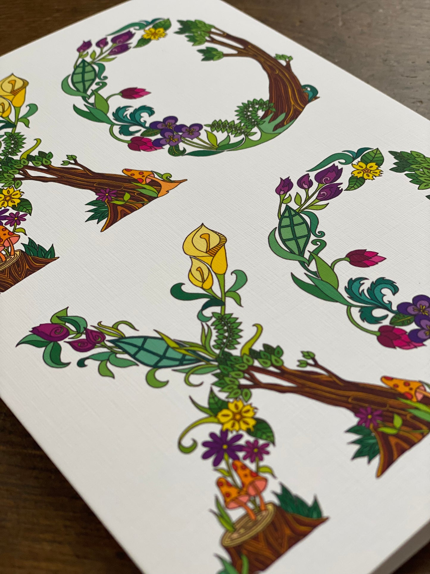 closeup of greeting card with botanical alphabet spelling xoxo.