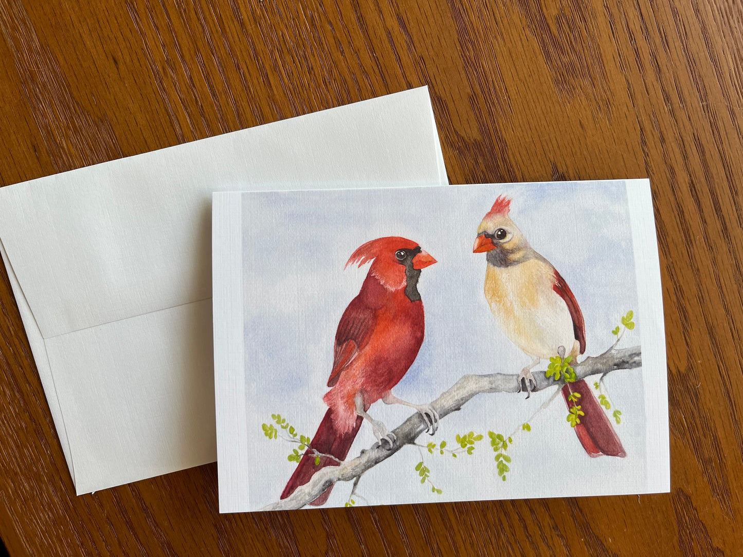 Greeting card and envelope with a watercolor painting of a male and female cardinal sitting on a branch.