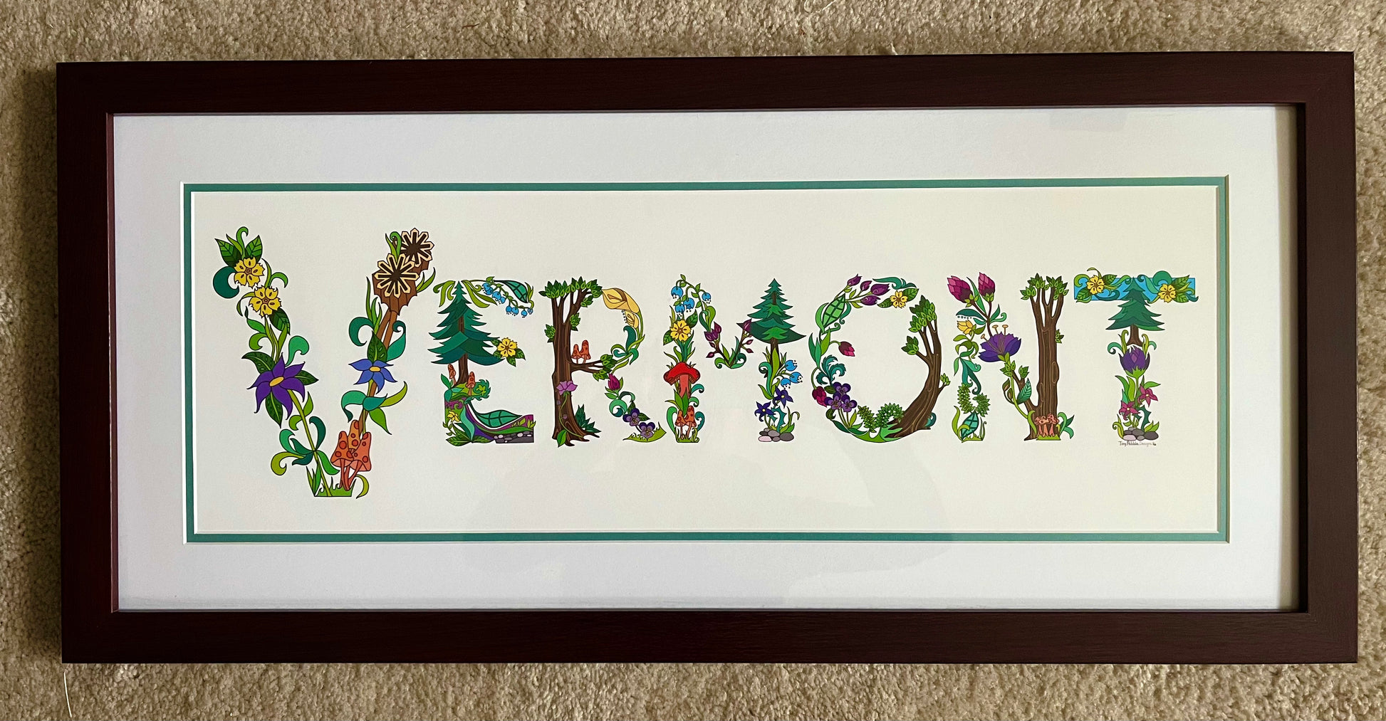 Art print of botanical lettering spelling the word, Vermont framed in a brown frame. 