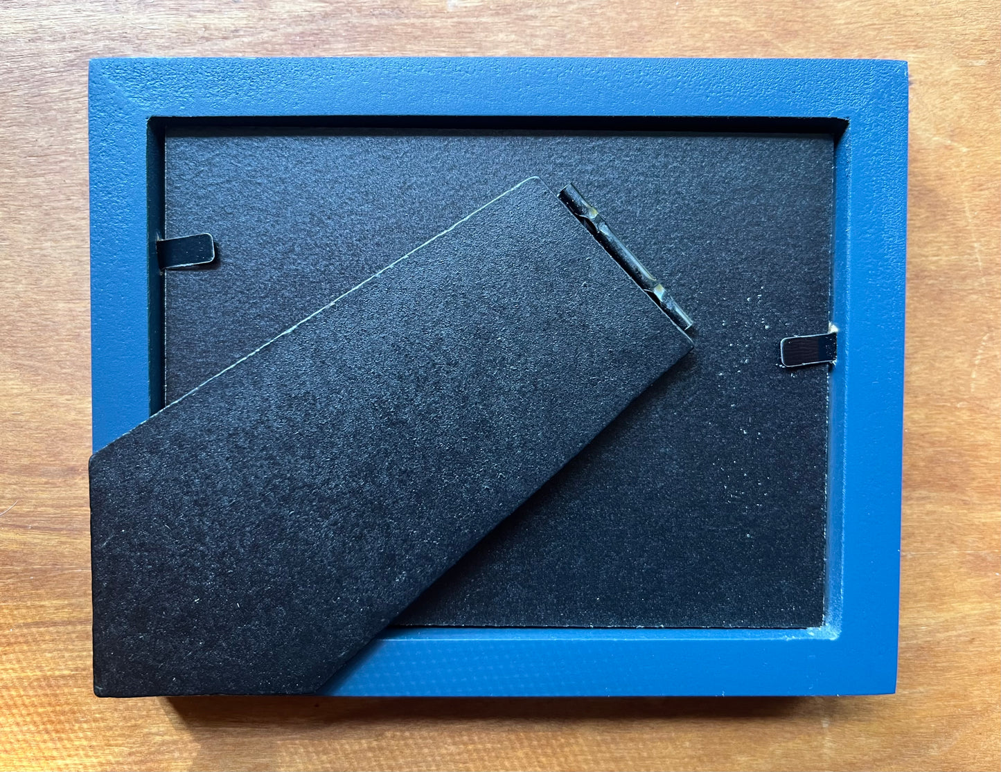 The back of a blue picture frame. 
