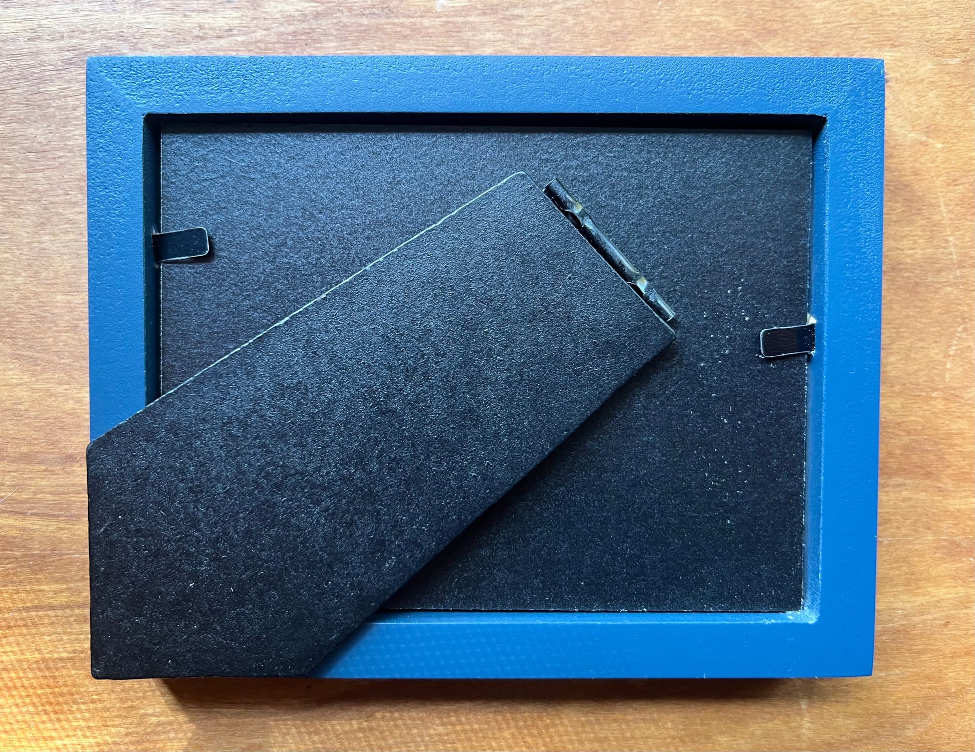 The back of a blue picture frame. 
