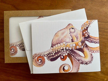 Watercolor painting of an octopus prints on a greeting card.