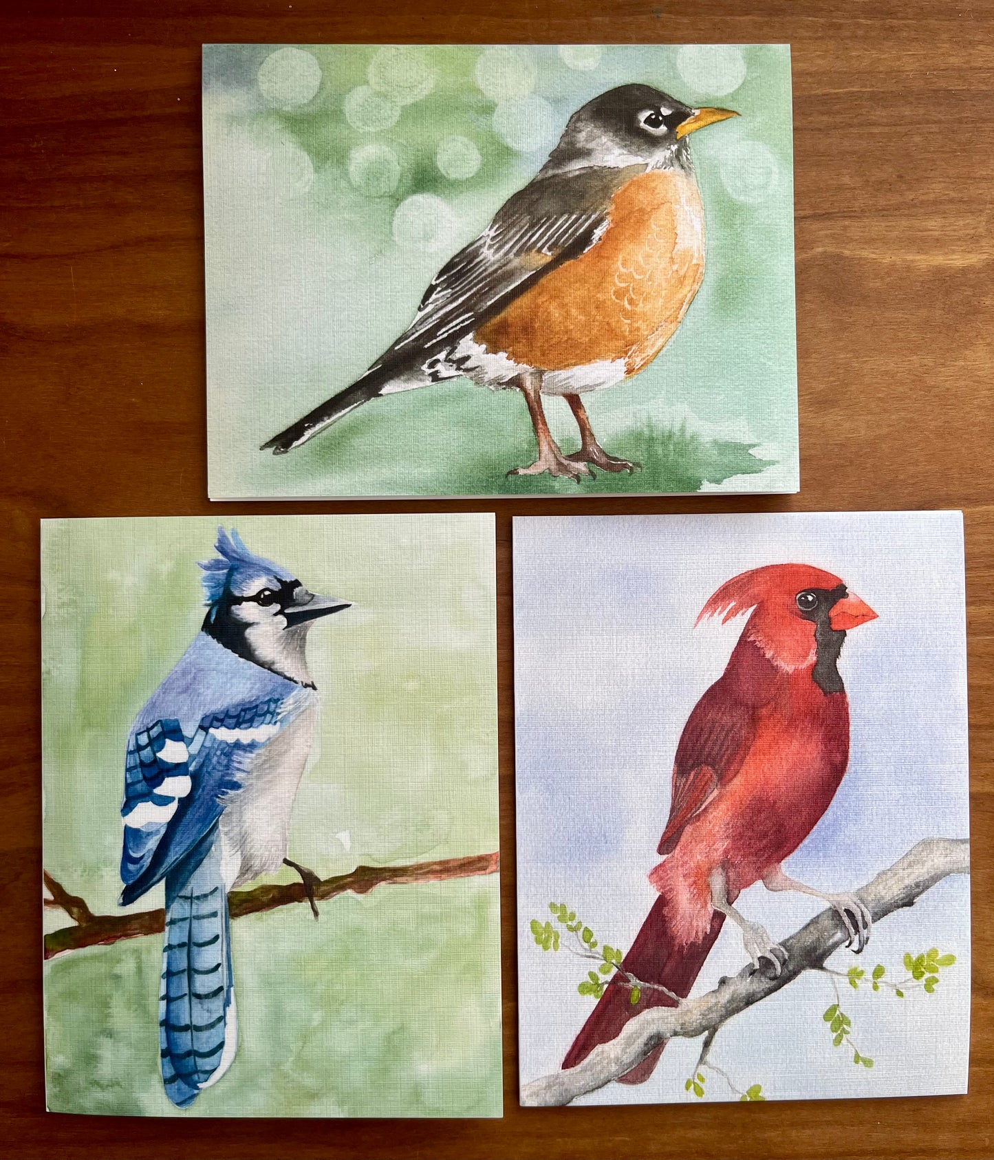 Set of three greeting cards with watercolor paintings of a robin, bluejay and male cardinal. 