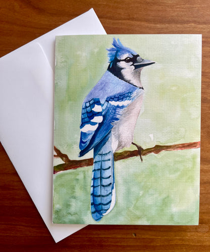 Greeting card with a watercolor painting of a bluejay along with a white envelope. 