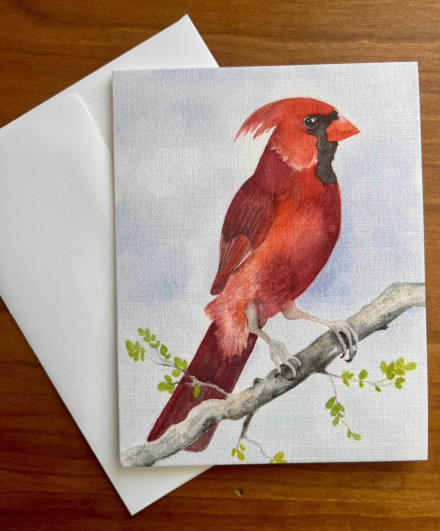 Greeting card with a watercolor painting of a male cardinal along with a white envelope. 