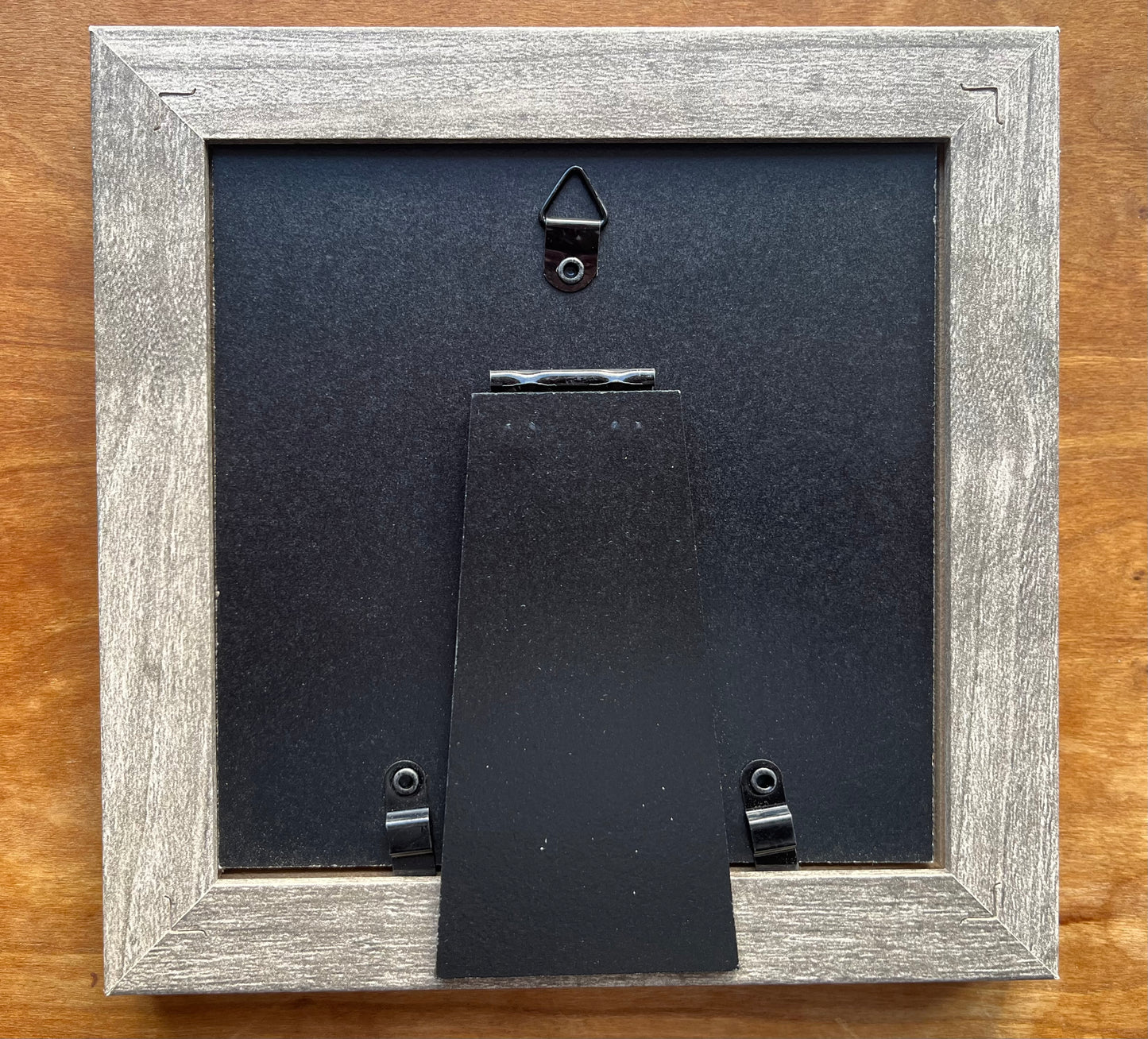 Back view of a grey square picture frame. 