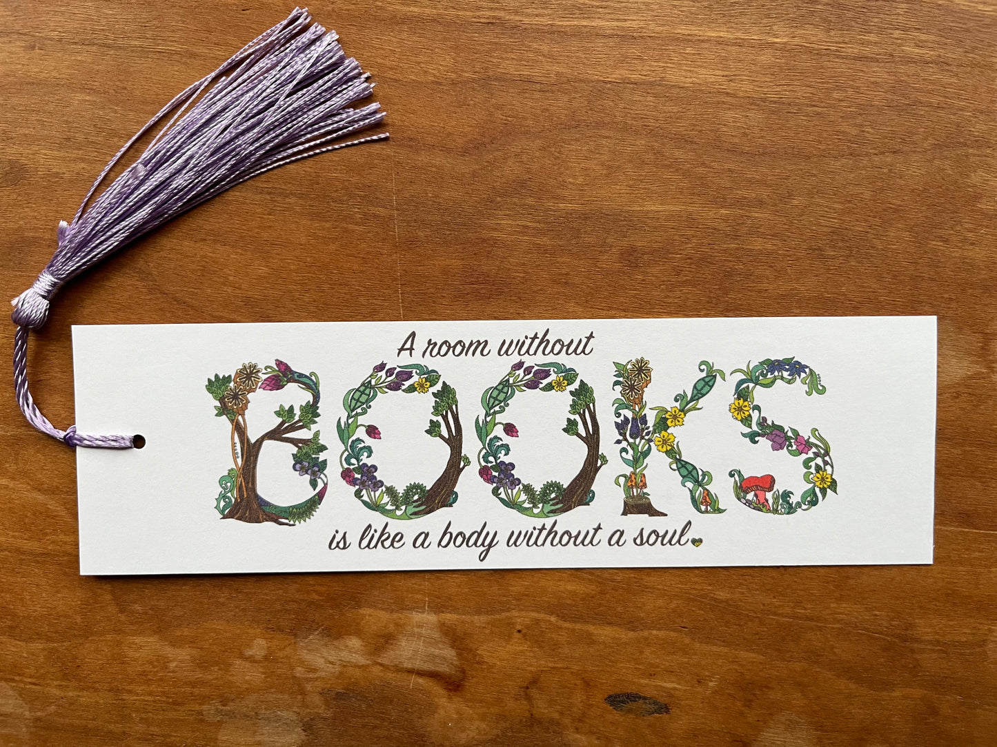 bookmark with botanical text that says, "a room without books is like a body without a soul".