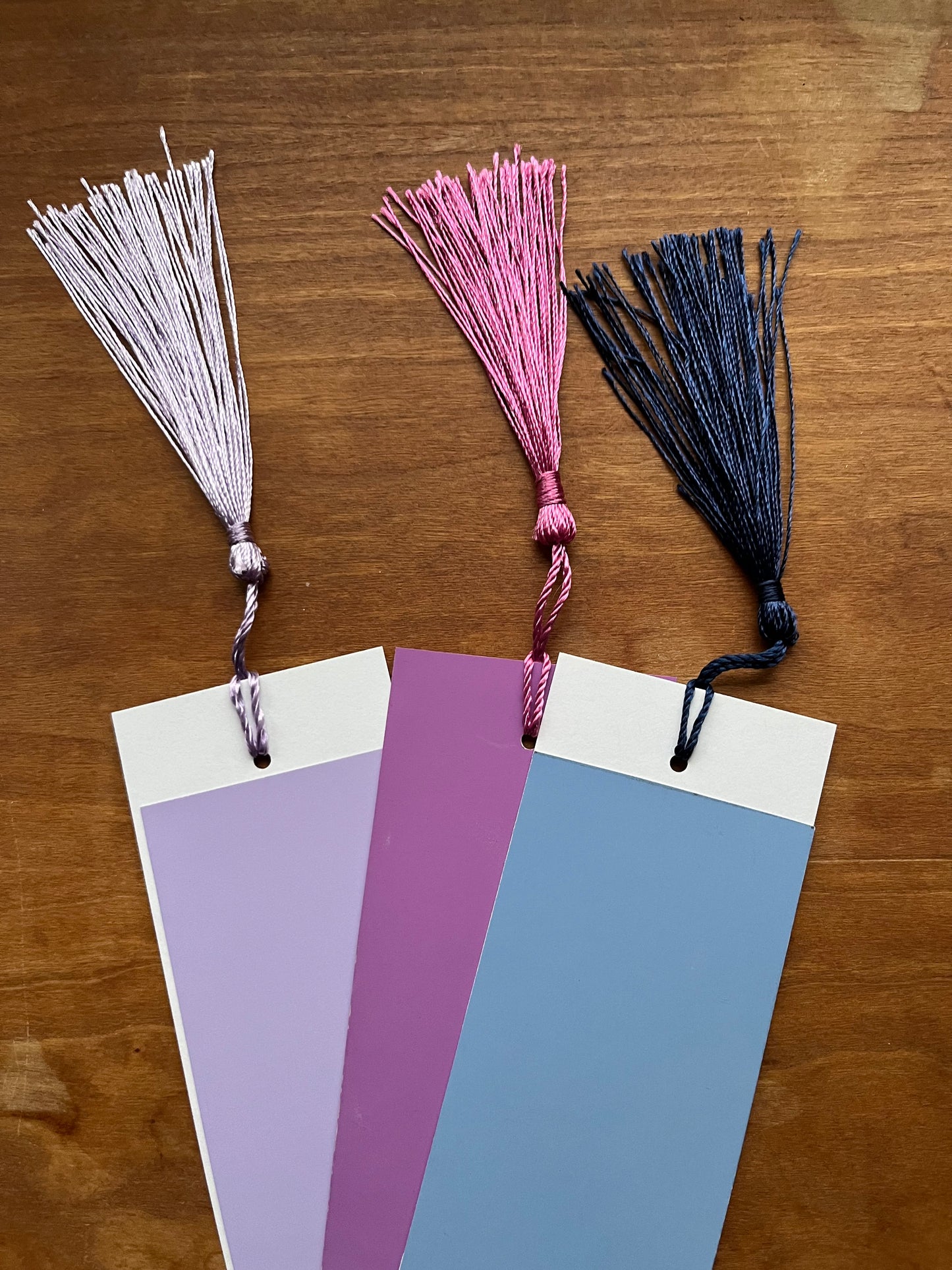 three colorful bookmarks with tassels.