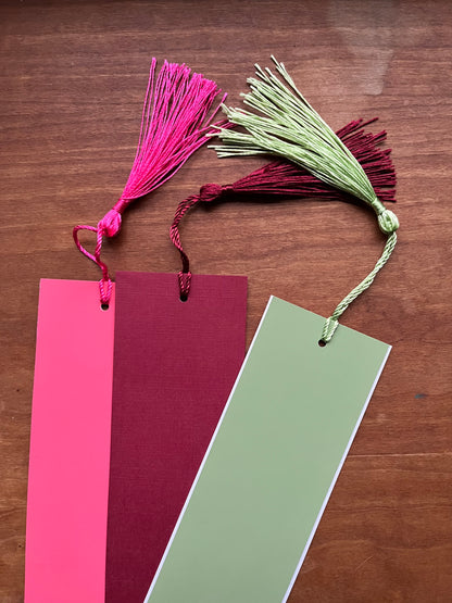 three colorful bookmarks with tassels.