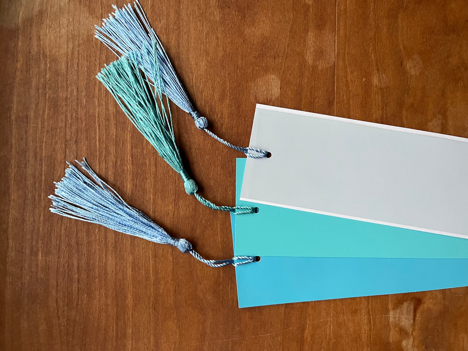 three blue bookmarks with tassels.