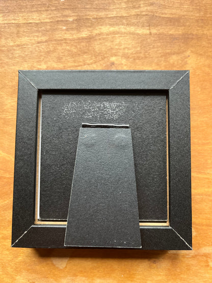 Back of a black square picture frame. 